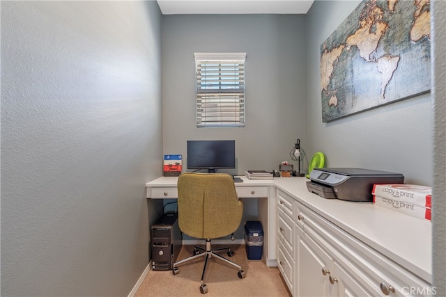 office space with baseboards and light carpet