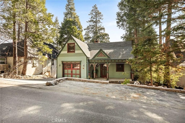 229 Maple Dr, Lake Arrowhead, CA 92352 - victorian-style house featuring a porch, asphalt driveway, a garage, a chimney, and roof with shingles