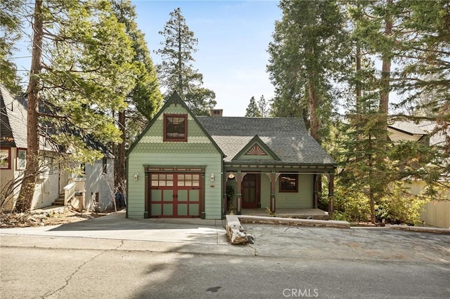 229 Maple Dr, Lake Arrowhead, CA 92352 - victorian house with a porch, a shingled roof, a garage, driveway, and a chimney