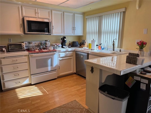 344 Ultimo Ave, Long Beach, CA 90814 - kitchen featuring appliances with stainless steel finishes, a sink, tile countertops, and white cabinets