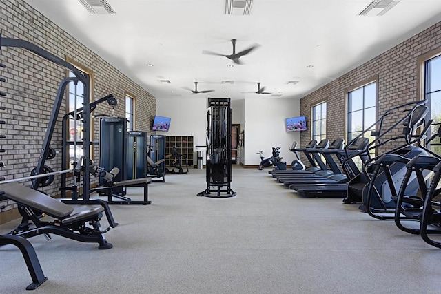 workout area featuring visible vents, ceiling fan, and brick wall