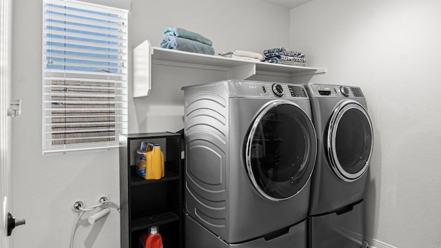 laundry area featuring a wealth of natural light, washing machine and clothes dryer, and laundry area