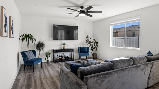 living area featuring baseboards, wood finished floors, and ceiling fan