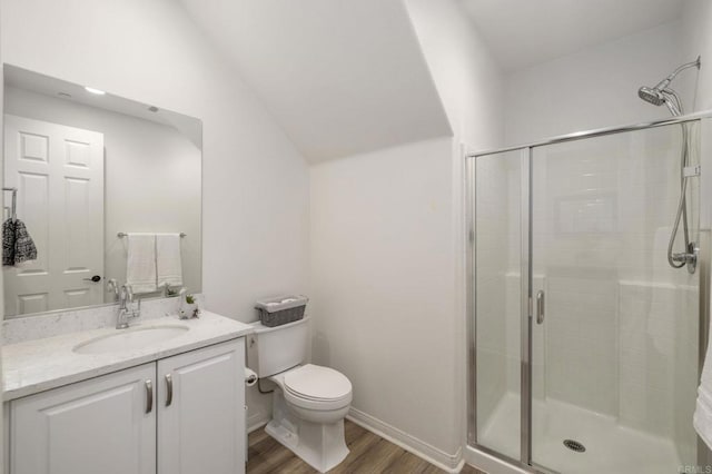 full bath featuring vanity, toilet, a stall shower, vaulted ceiling, and wood finished floors