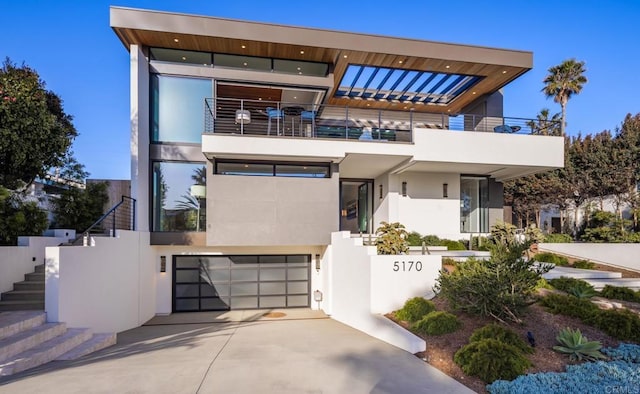 5170 Carlsbad Blvd, Carlsbad, CA 92008 - contemporary house featuring a balcony, stairs, concrete driveway, stucco siding, and a garage