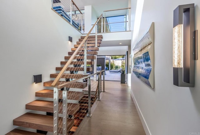 5170 Carlsbad Blvd, Carlsbad, CA 92008 - stairs featuring wood finished floors, baseboards, and a towering ceiling