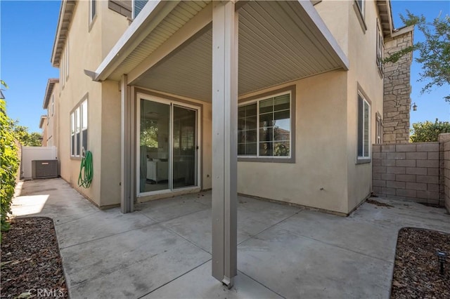 view of patio featuring central AC unit and fence