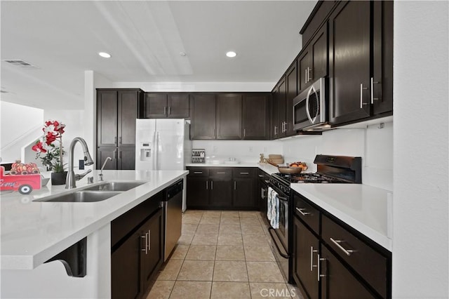 kitchen featuring stainless steel appliances, light countertops, a sink, and light tile patterned flooring