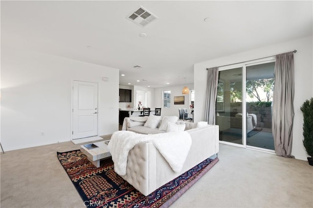 living area featuring light colored carpet, baseboards, visible vents, and recessed lighting