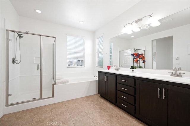 full bath featuring a sink, a shower stall, double vanity, and a garden tub