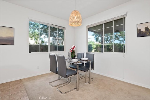 dining room featuring a healthy amount of sunlight, baseboards, and tile patterned flooring