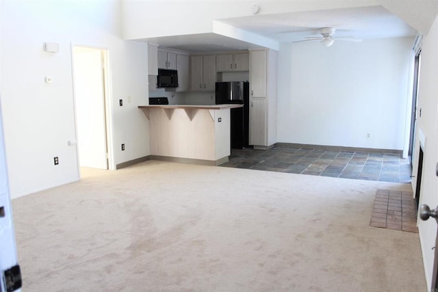 kitchen with carpet floors, ceiling fan, black appliances, and a peninsula
