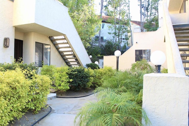 exterior space with stairs and stucco siding