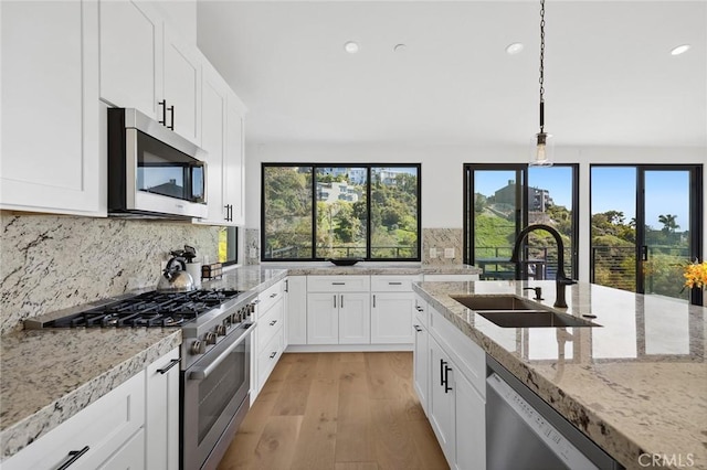 990 Meadowlark Dr, Laguna Beach, CA 92651 - kitchen with stainless steel appliances, light wood finished floors, a sink, and decorative backsplash