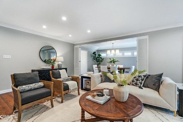 living area with baseboards, a chandelier, recessed lighting, crown molding, and light wood finished floors