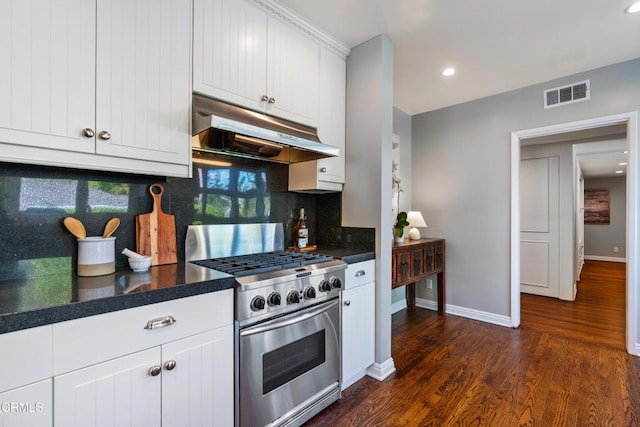 kitchen with stainless steel range with gas cooktop, tasteful backsplash, visible vents, under cabinet range hood, and dark countertops
