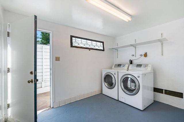 washroom featuring washing machine and dryer, laundry area, and baseboards