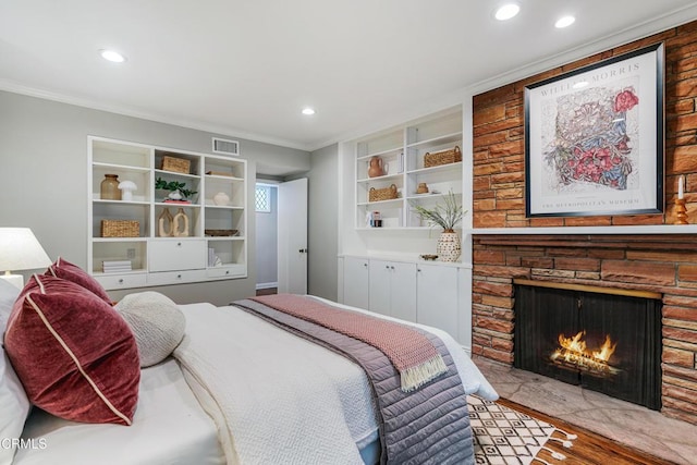 bedroom with visible vents, a stone fireplace, crown molding, recessed lighting, and wood finished floors
