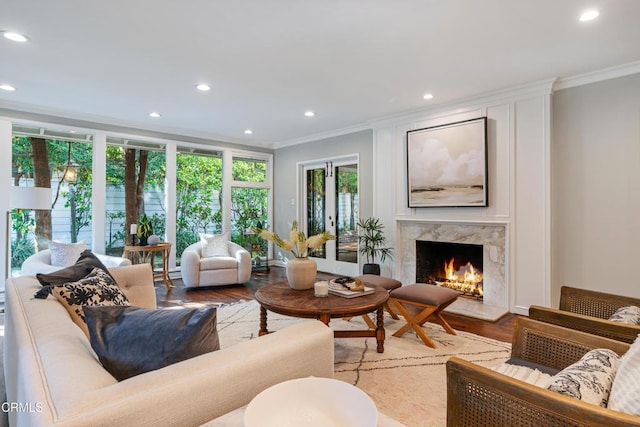 living area featuring ornamental molding, recessed lighting, french doors, a high end fireplace, and wood finished floors