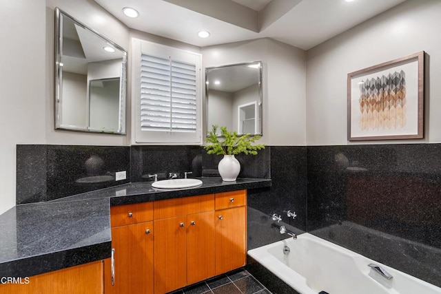 bathroom featuring tasteful backsplash, vanity, recessed lighting, and a washtub