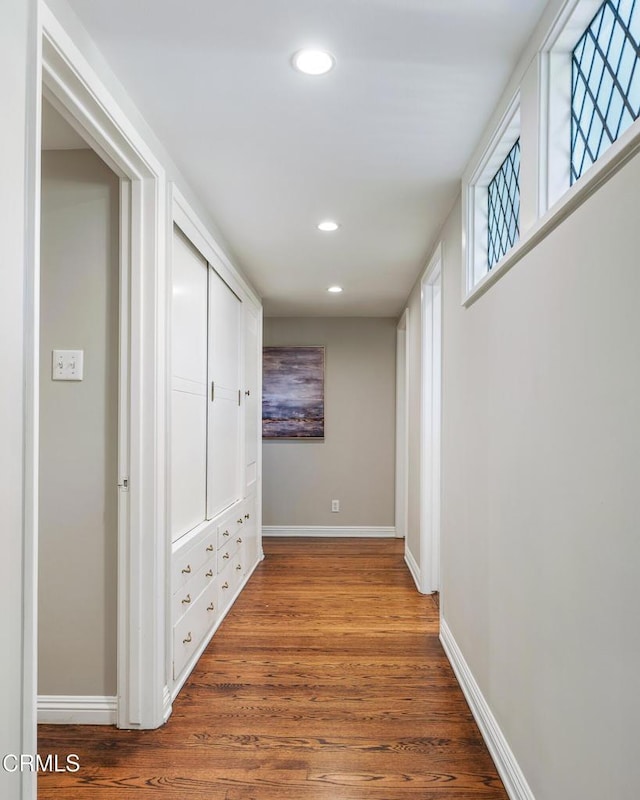 hallway with baseboards, recessed lighting, and wood finished floors
