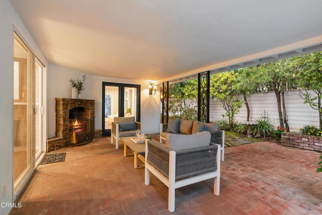 view of patio featuring an outdoor living space with a fireplace and fence