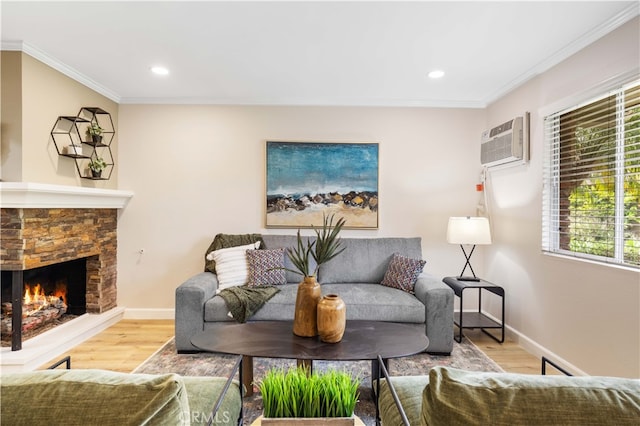 living area with crown molding, an AC wall unit, a stone fireplace, and wood finished floors