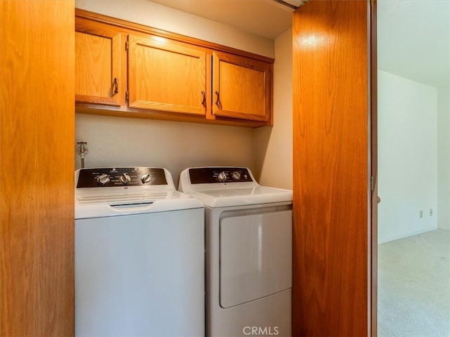 washroom with cabinet space, carpet flooring, and independent washer and dryer