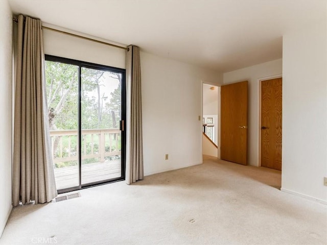 carpeted empty room featuring visible vents