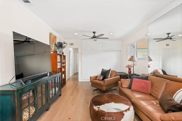 living area with ornamental molding, a ceiling fan, and light wood-style floors