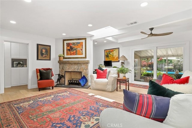 living room with wood finished floors, a fireplace, a ceiling fan, and recessed lighting