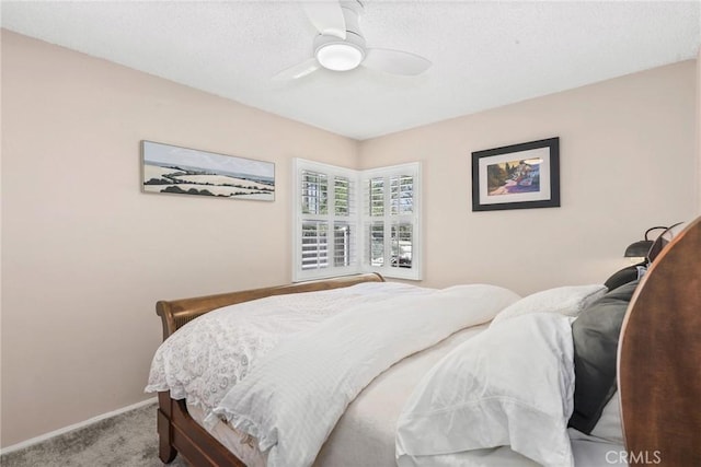 bedroom with a textured ceiling, baseboards, a ceiling fan, and carpet floors