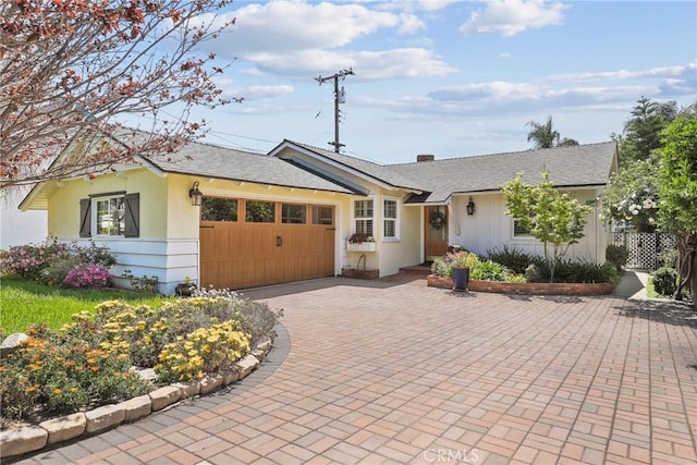 ranch-style home with stucco siding, fence, an attached garage, a shingled roof, and driveway