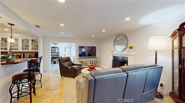 living area with baseboards, a fireplace, recessed lighting, a ceiling fan, and visible vents