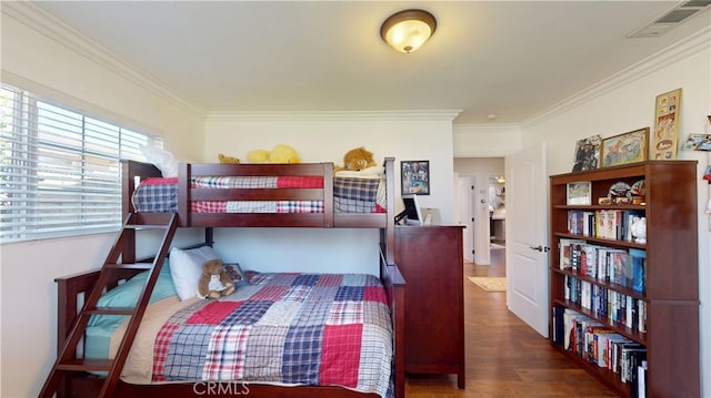 bedroom with wood finished floors, ornamental molding, and visible vents