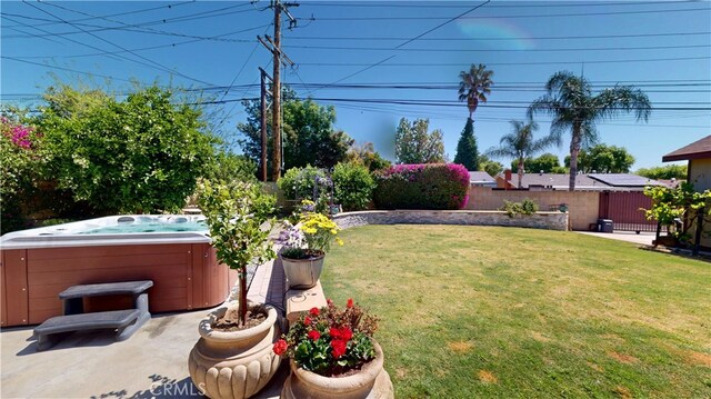 view of yard featuring a patio, fence, and a hot tub