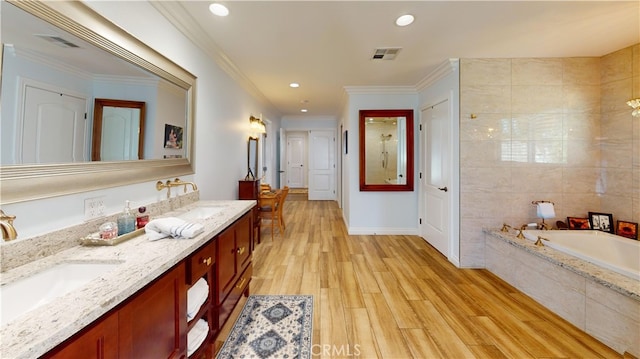 full bathroom with a garden tub, double vanity, visible vents, and a sink