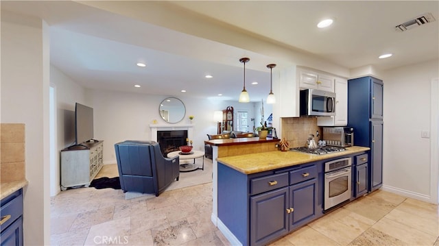 kitchen featuring a fireplace, open floor plan, backsplash, visible vents, and appliances with stainless steel finishes