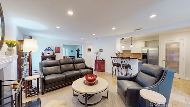 living area with visible vents, baseboards, and recessed lighting