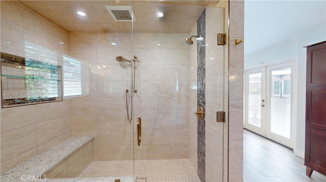 bathroom featuring a stall shower, french doors, visible vents, and plenty of natural light