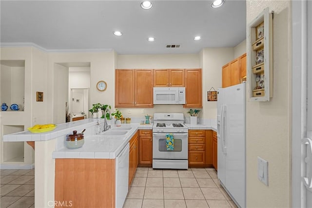 kitchen with tile countertops, white appliances, a peninsula, light tile patterned flooring, and a sink