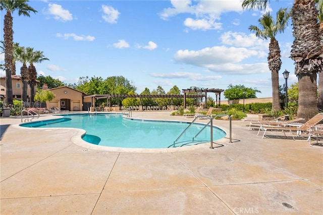 community pool with a patio, a pergola, and fence