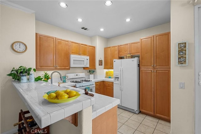 kitchen featuring white appliances, a peninsula, visible vents, recessed lighting, and tile counters