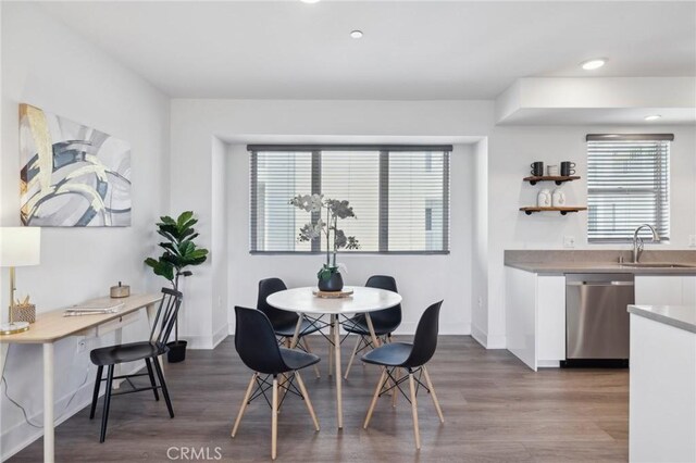 dining area featuring baseboards, recessed lighting, wood finished floors, and bar