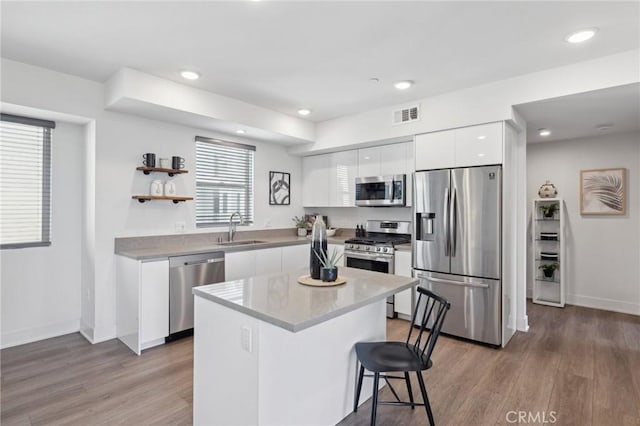 kitchen with white cabinets, a sink, appliances with stainless steel finishes, visible vents, and modern cabinets