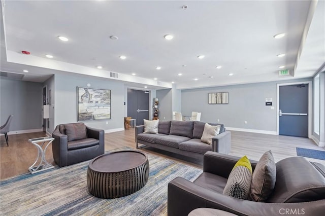 living room featuring baseboards, visible vents, light wood-style flooring, and recessed lighting