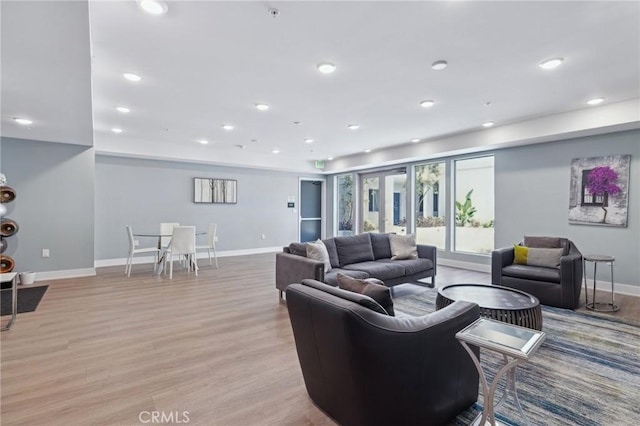 living room with light wood-style floors, recessed lighting, and baseboards