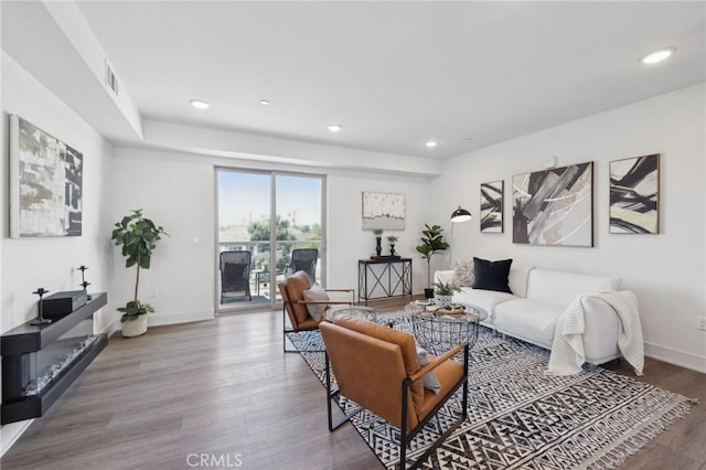 living area featuring recessed lighting, wood finished floors, and baseboards