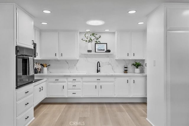 1600 Northwood Rd Unit M11-275B, Seal Beach, CA 90740 - kitchen with open shelves, a sink, light countertops, white cabinetry, and black oven