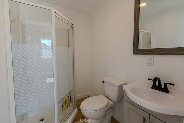 full bath with toilet, a shower stall, vanity, and baseboards